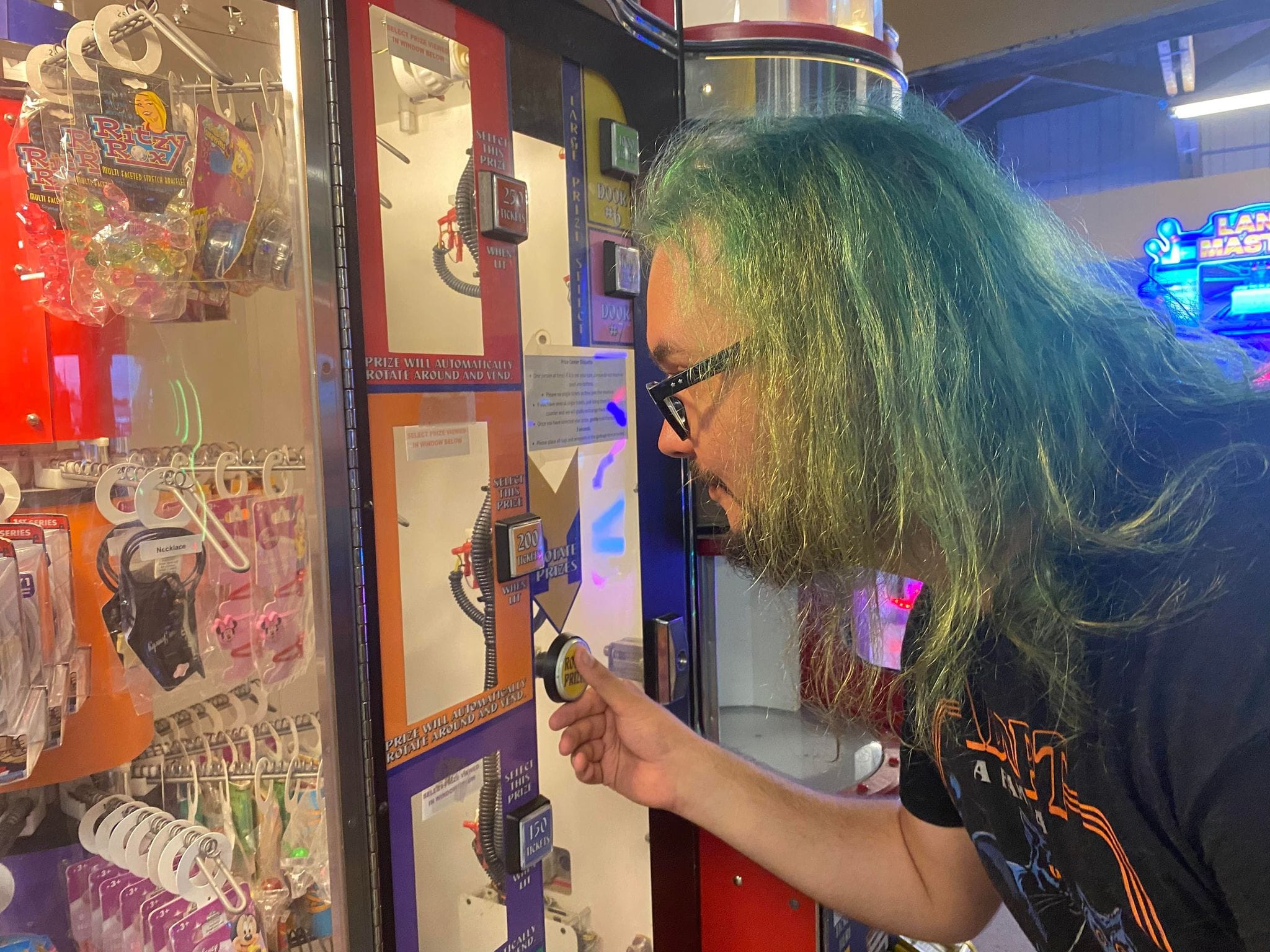 A man with green hair examines available prizes, Photo 2